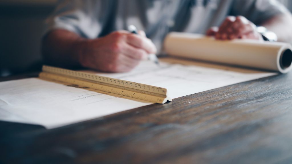 Carpenter measuring and marking lumber on a workbench