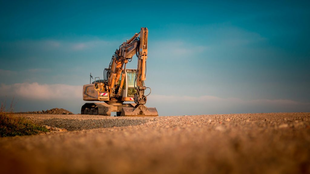 Excavator arm against a dusk sky on a job site